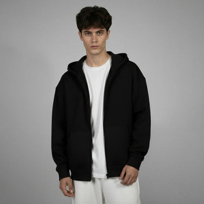 Person wearing a black hoodie over a white shirt on a gray background