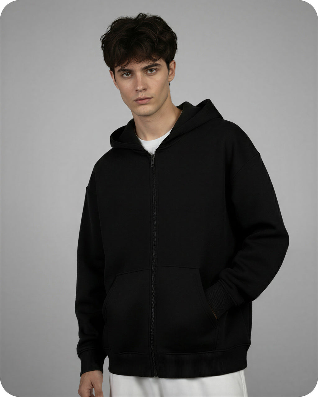 Person wearing a black hoodie on a gray background