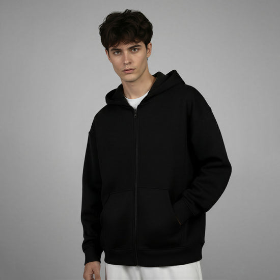 Person wearing a black hoodie on a gray background