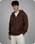 Man wearing a brown hoodie against a gray background
