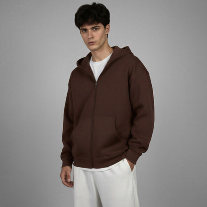Man wearing a brown hoodie against a gray background