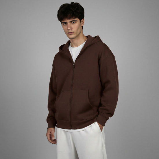 Man wearing a brown hoodie against a gray background