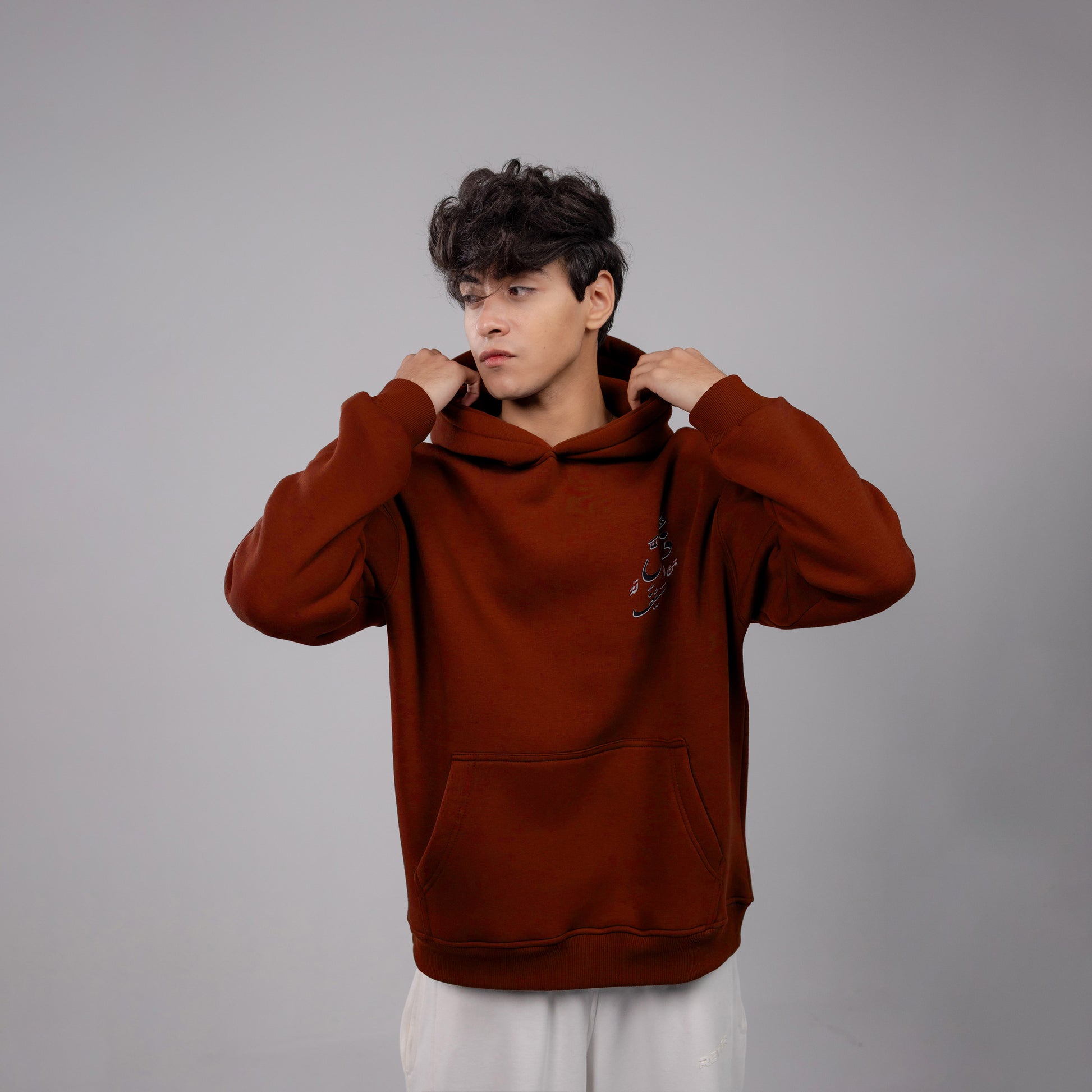 Person wearing a Burgundy hoodie against a gray background