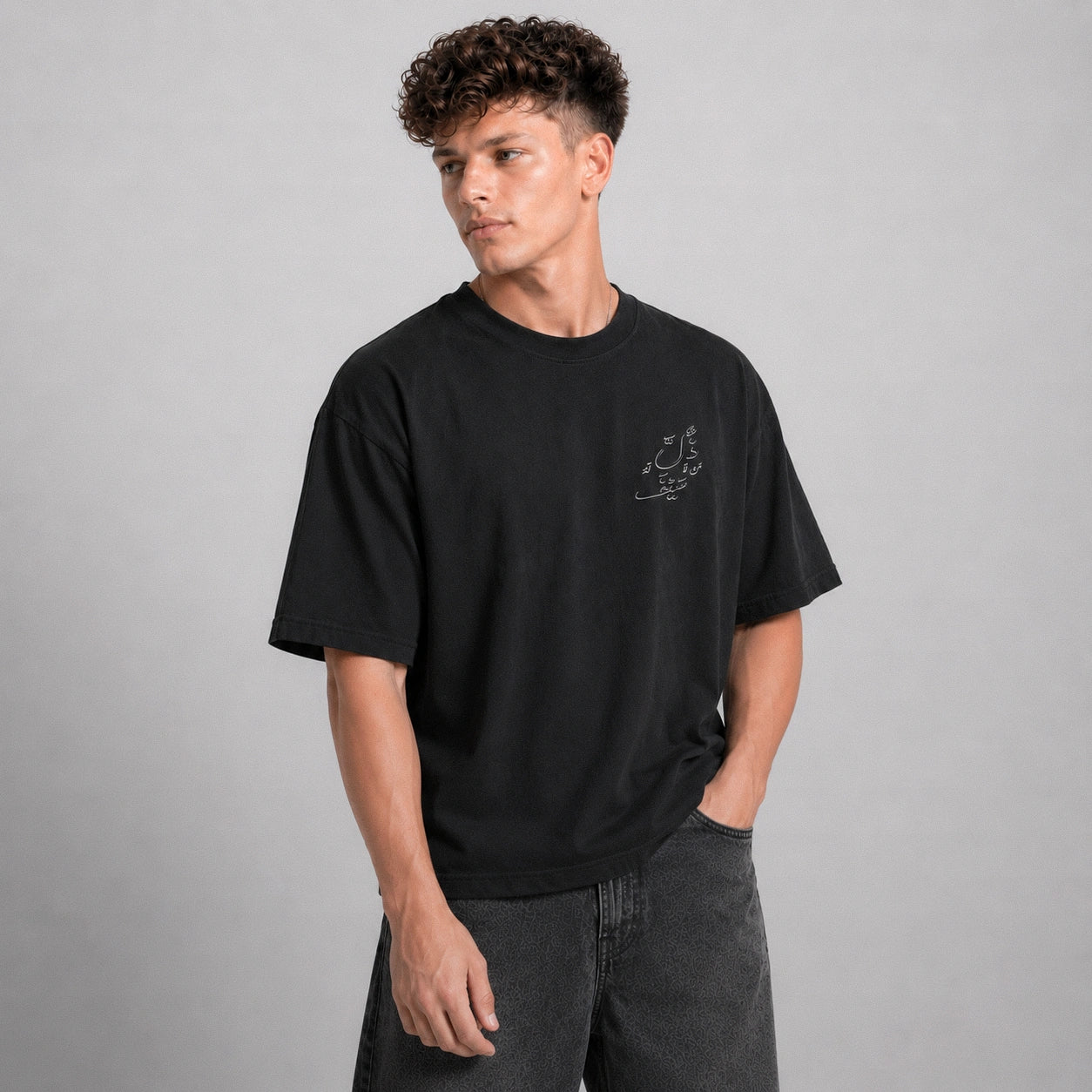 Person wearing a black t-shirt with text on a gray background