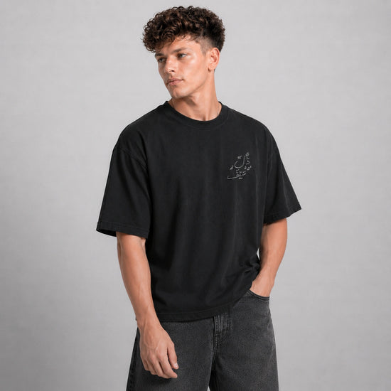 Person wearing a black t-shirt with text on a gray background