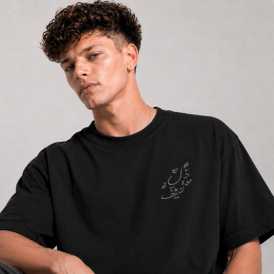 Man wearing a black t-shirt with white text on a gray background