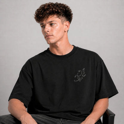Man wearing a black t-shirt with text on a gray background