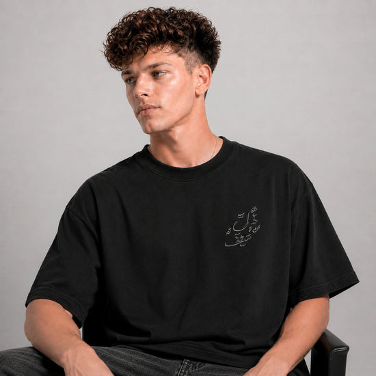 Man wearing a black t-shirt with text on a gray background