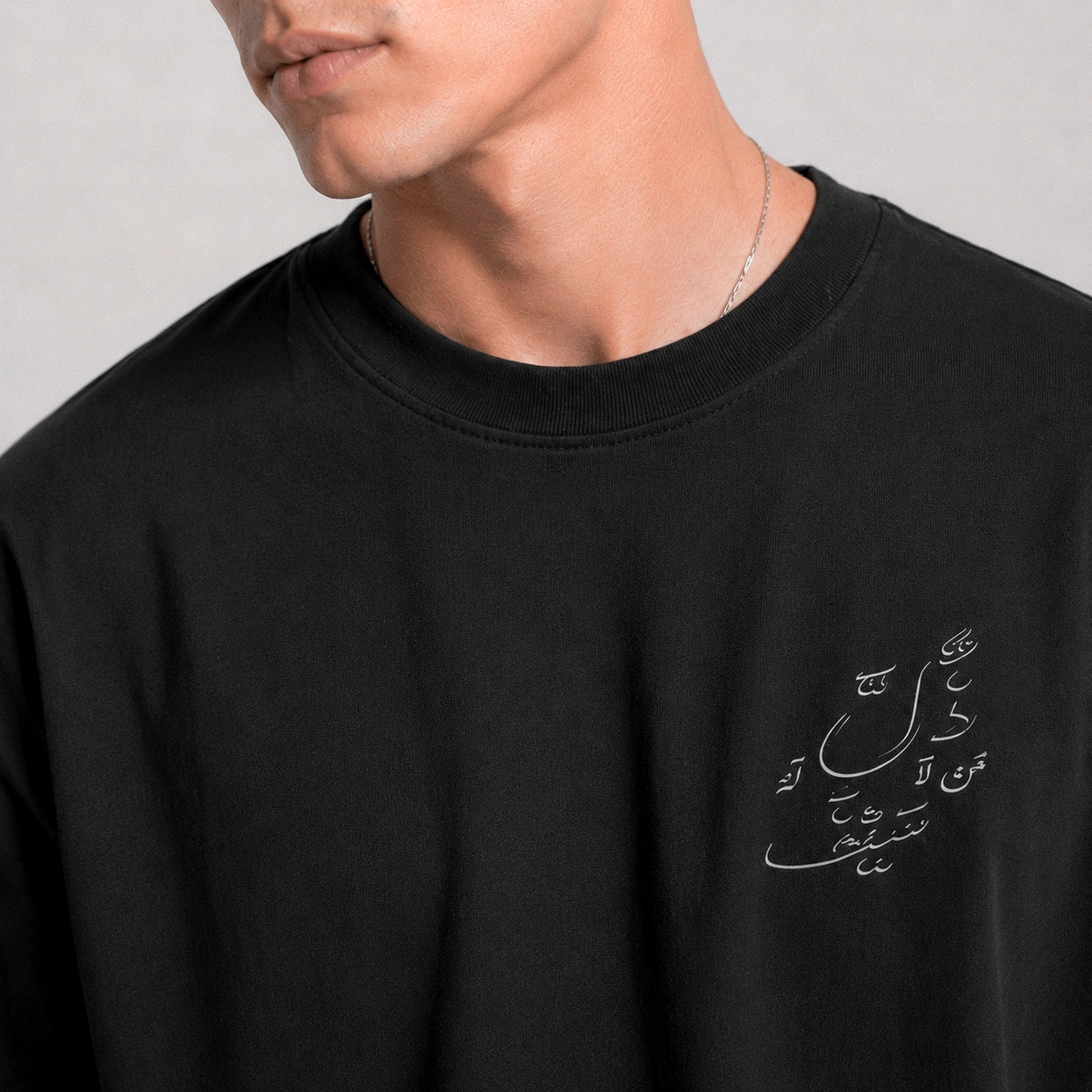 Black sweatshirt with Arabic text on a plain background