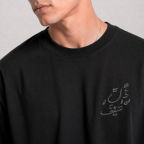 Black sweatshirt with Arabic text on a plain background
