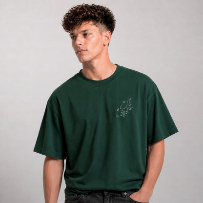 Man wearing a green t-shirt with text on a gray background