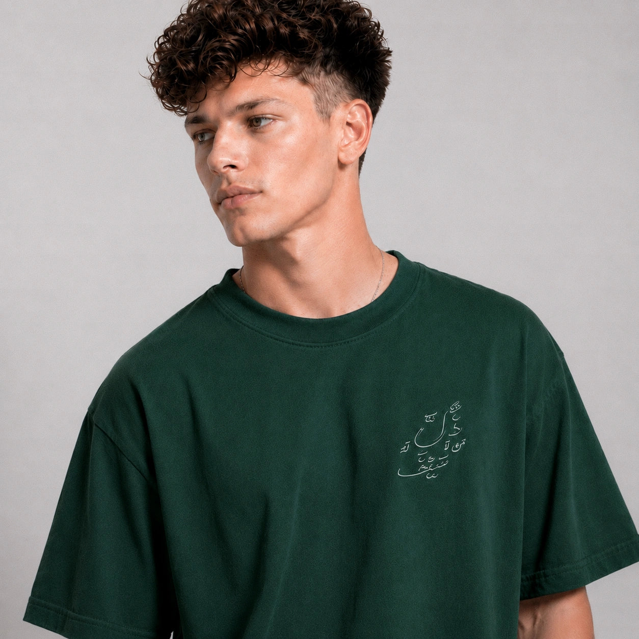 Man wearing a green t-shirt with text on a plain background