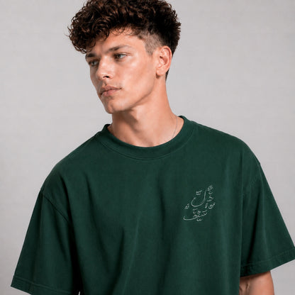 Man wearing a green t-shirt with text on a plain background