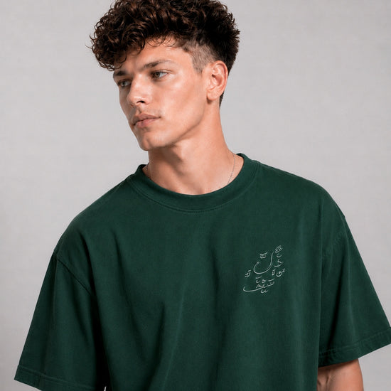 Man wearing a green t-shirt with text on a plain background