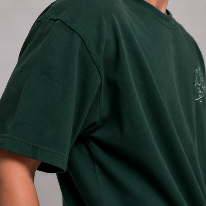 Green t-shirt with a small logo on a plain background