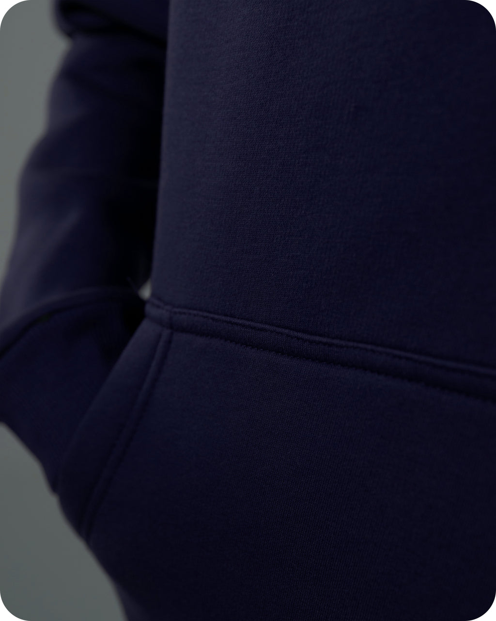 Close-up of a navy blue hoodie with a focus on the hood and sleeve.