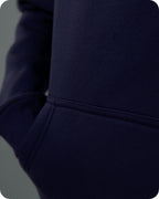 Close-up of a navy blue hoodie with a focus on the hood and sleeve.