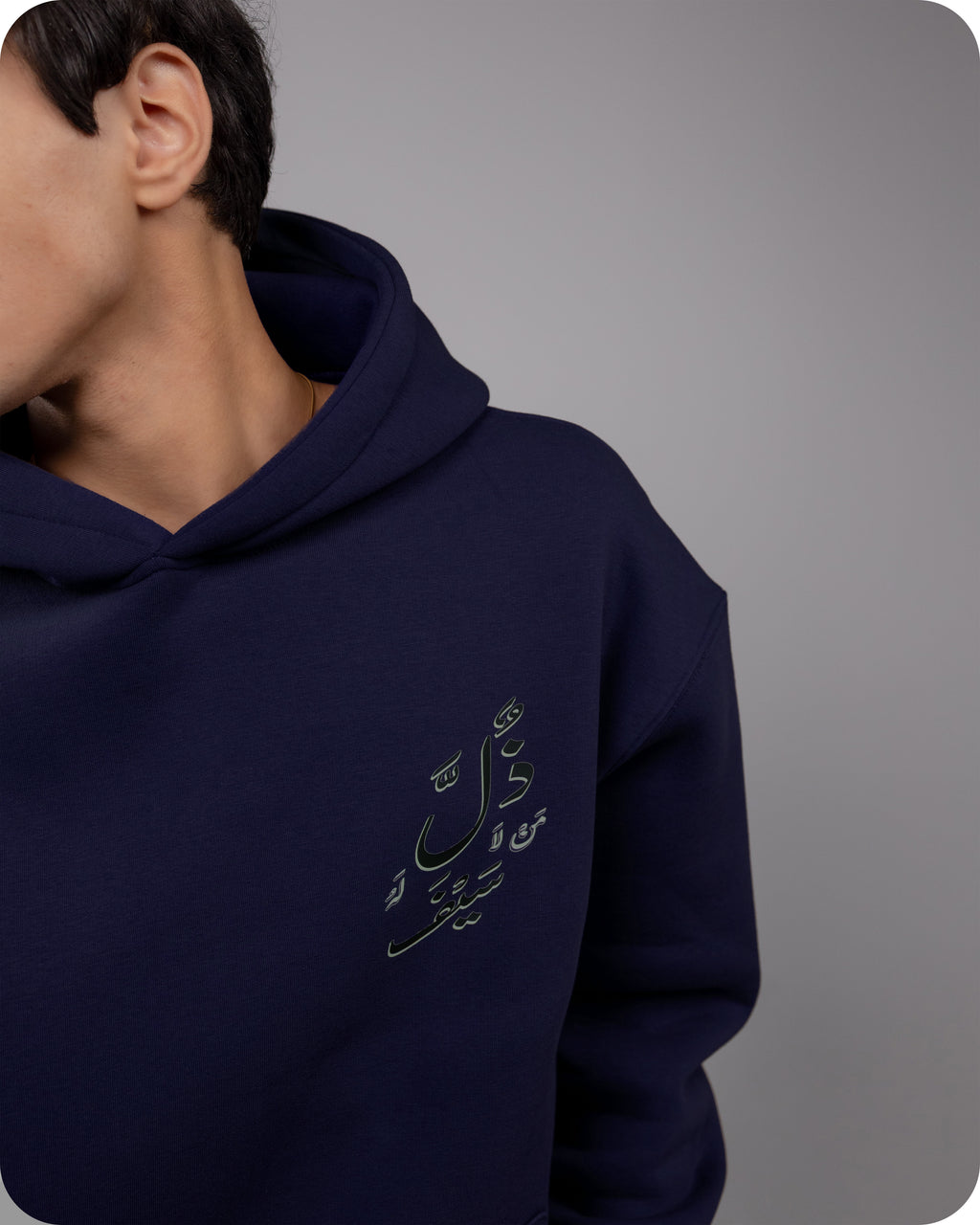 Navy blue hoodie with Arabic text on a gray background