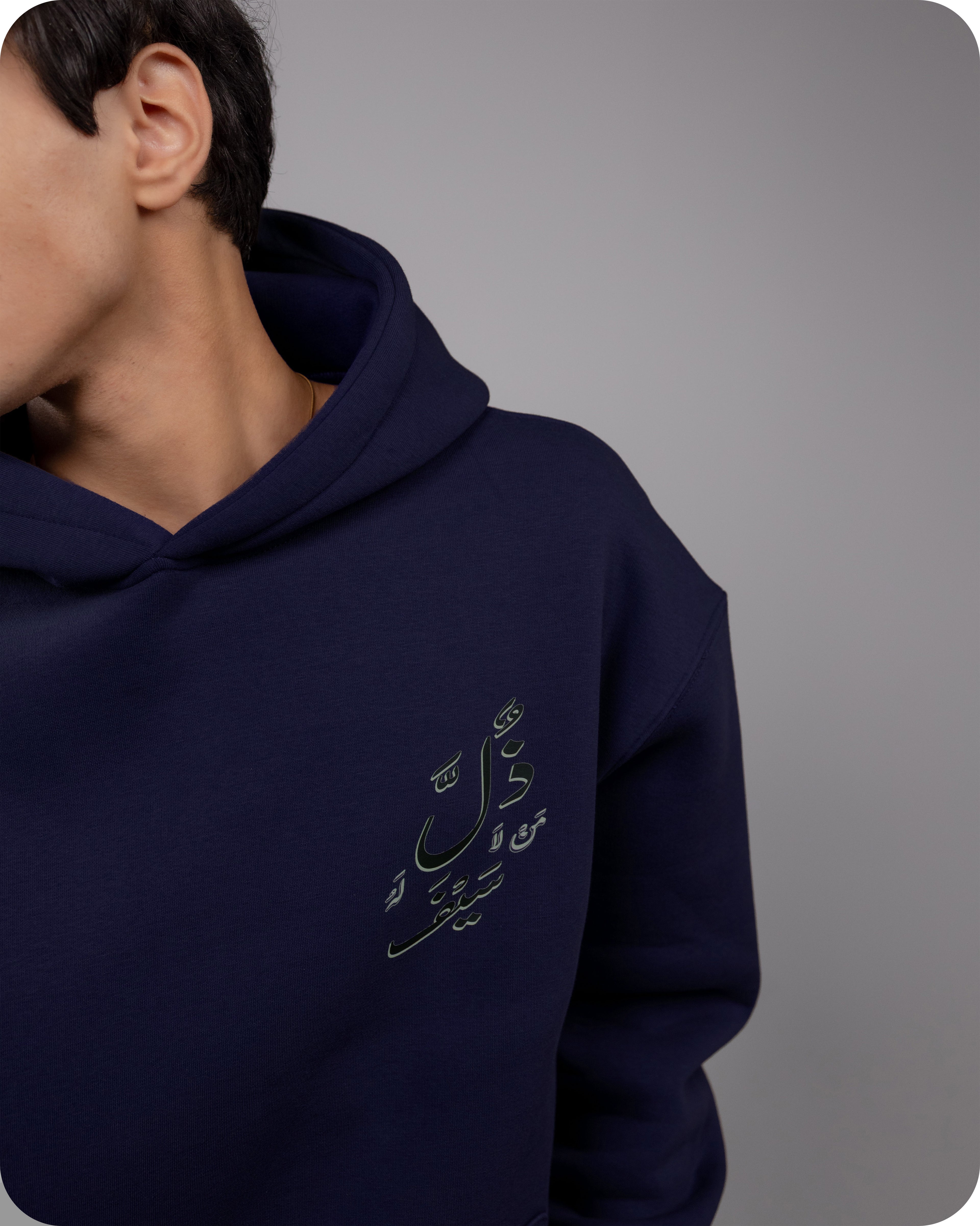 Navy blue hoodie with Arabic text on a gray background