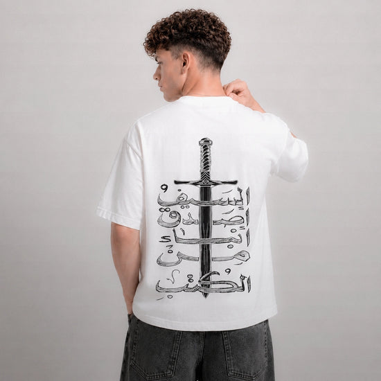 Person wearing a white t-shirt with a black sword and Arabic text design on the back against a gray background