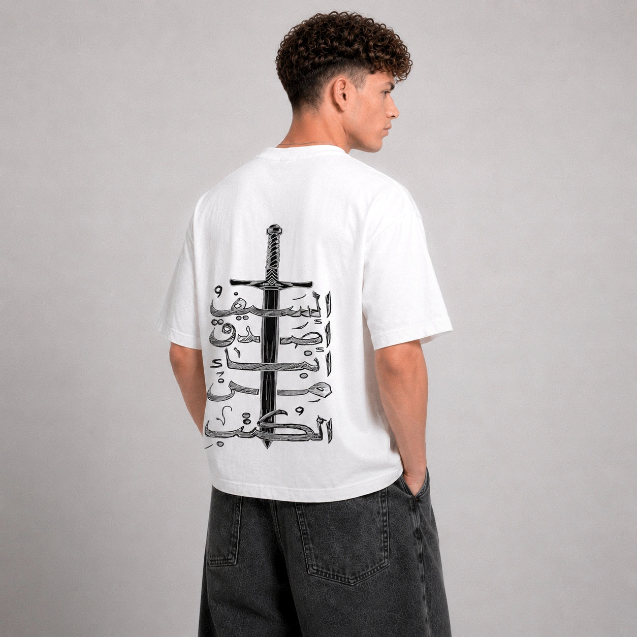 Person wearing a white t-shirt with a black design on the back against a gray background