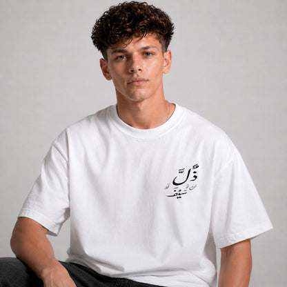 Person wearing a white t-shirt with Arabic text on a plain background