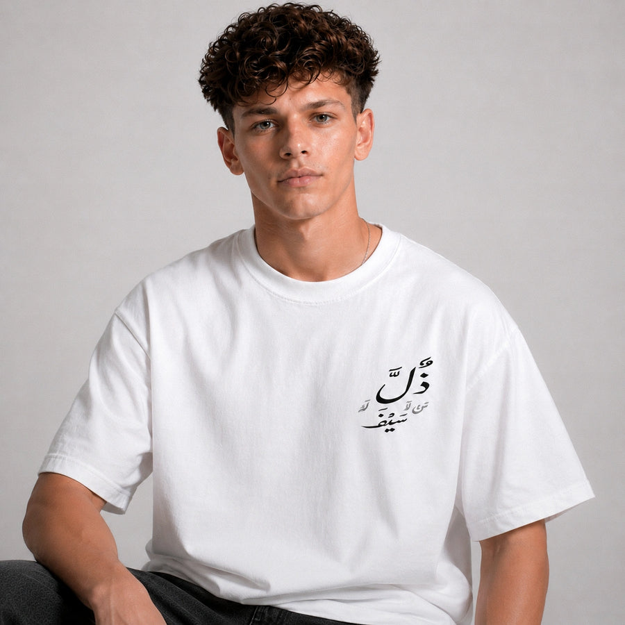 Person wearing a white t-shirt with Arabic text on a plain background