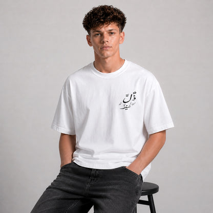 Person wearing a white t-shirt with Arabic text on a gray background