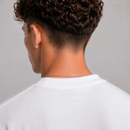 Person wearing a white shirt with a neutral background
