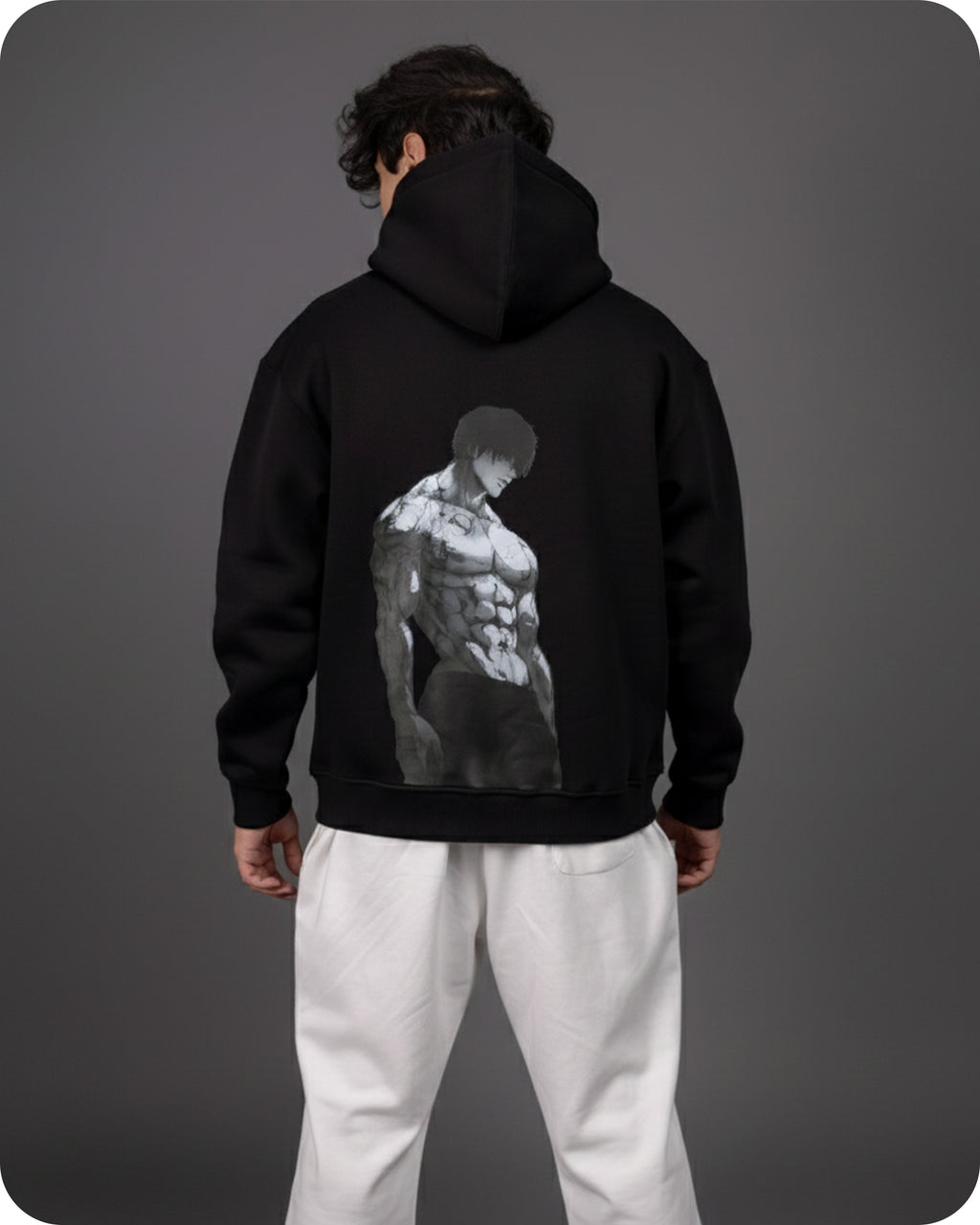 Person wearing a black hoodie with a graphic design on the back against a gray background