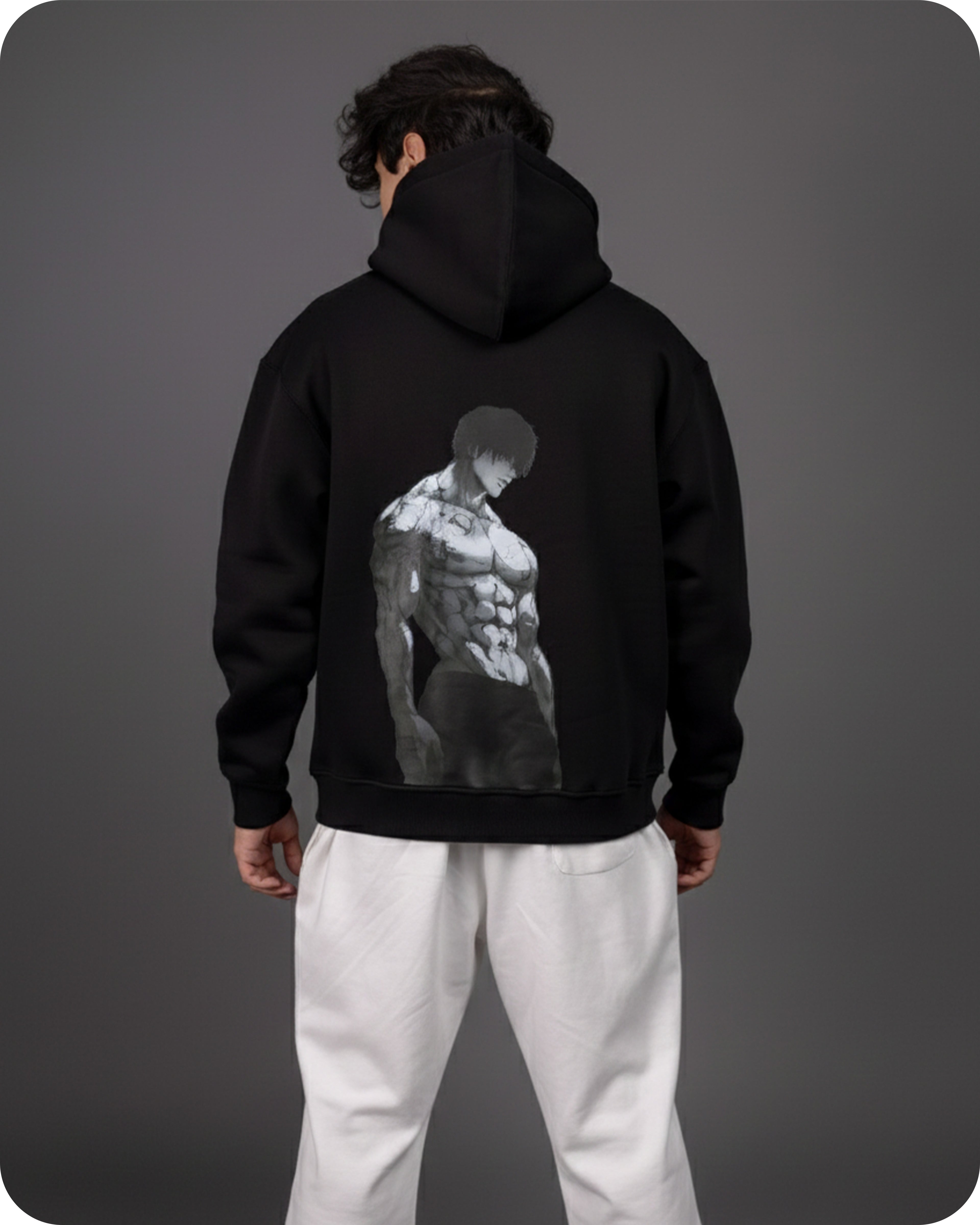 Person wearing a black hoodie with a graphic design on the back against a gray background