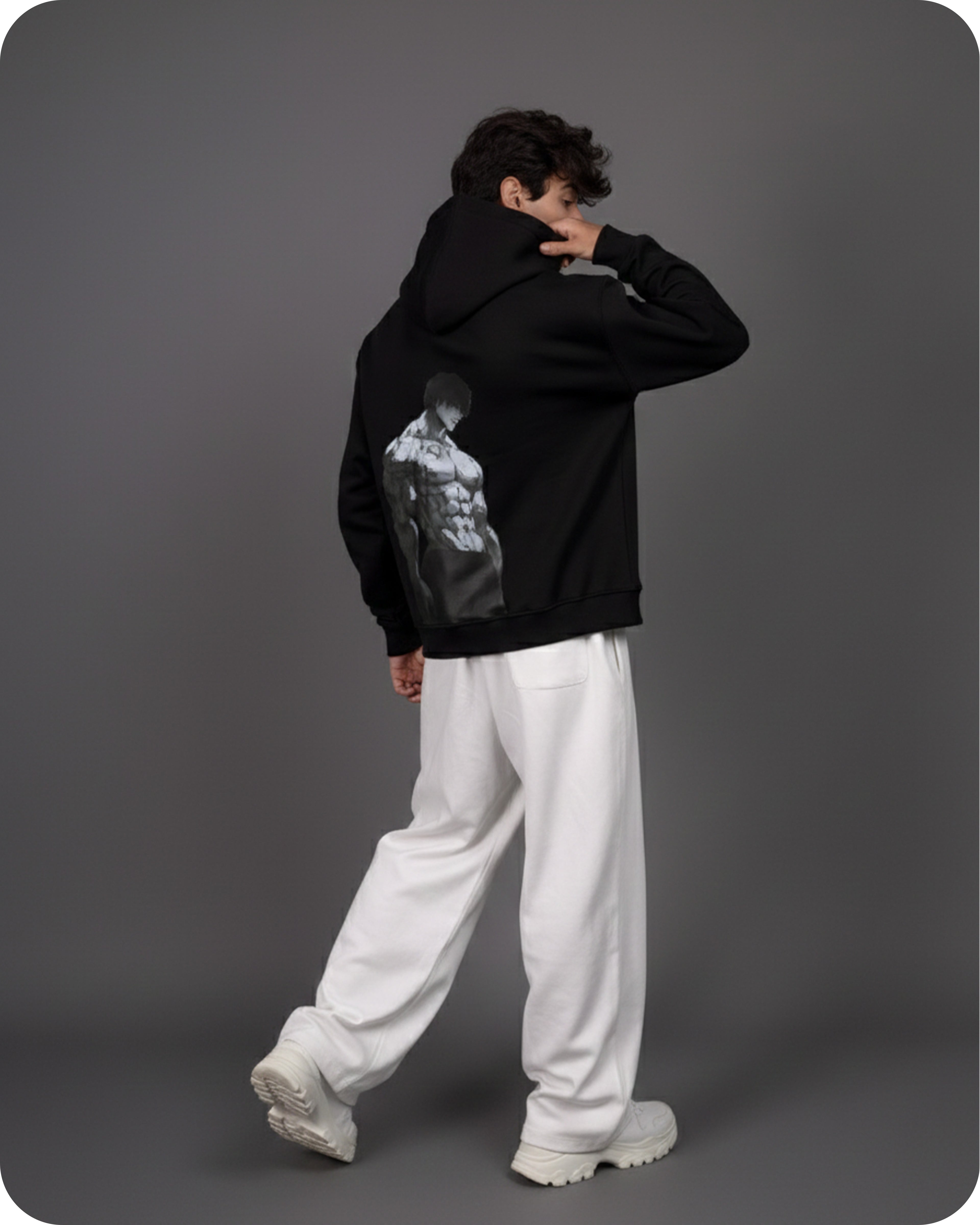 Person wearing a black hoodie with a graphic design on the back against a gray background