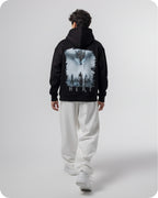 Person wearing a black hoodie with 'Winter is Here' text on the back, standing against a white background