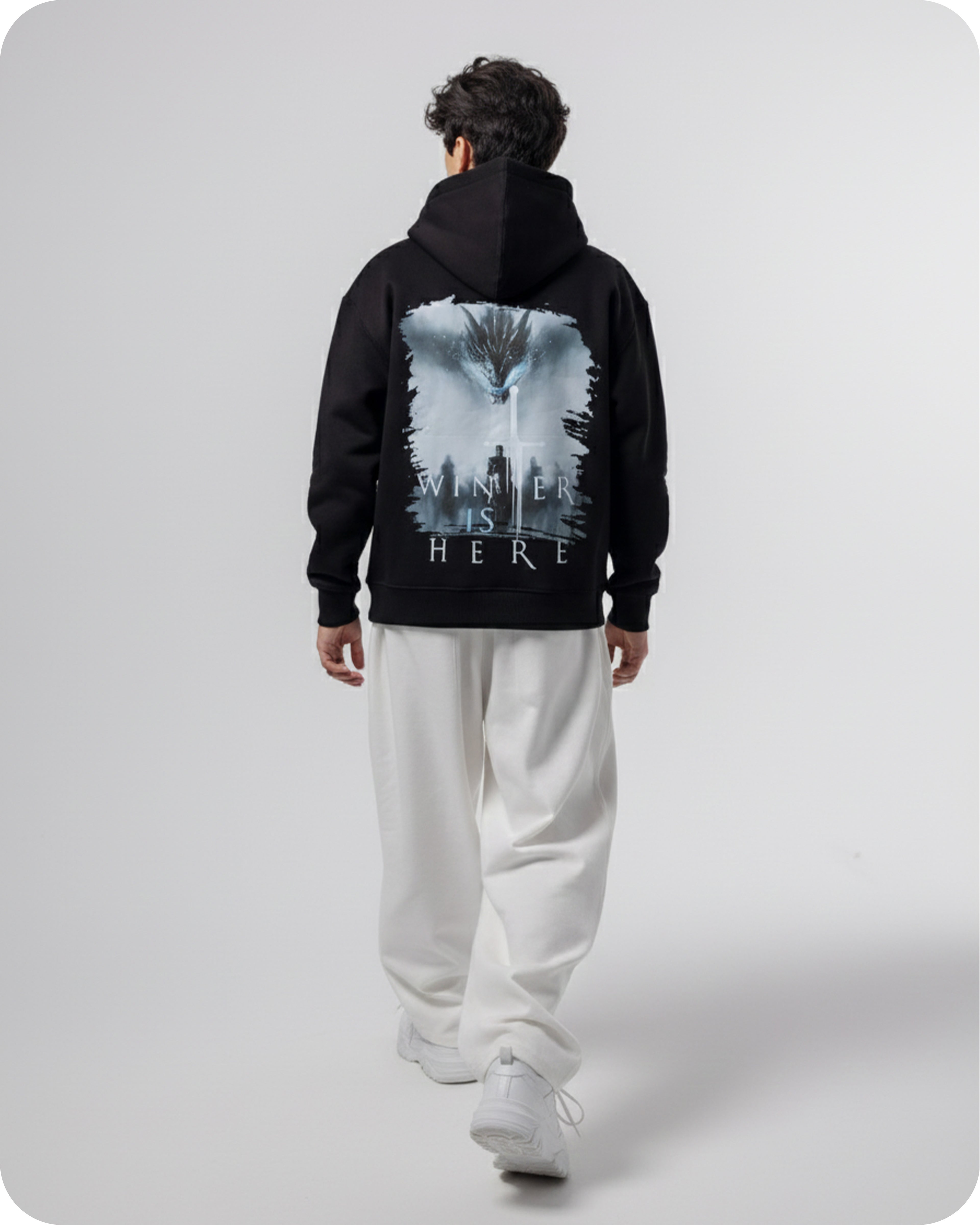 Person wearing a black hoodie with 'Winter is Here' text on the back, standing against a white background